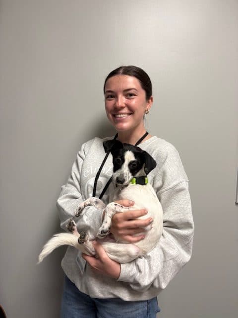 MAggie holding a black and white puppy